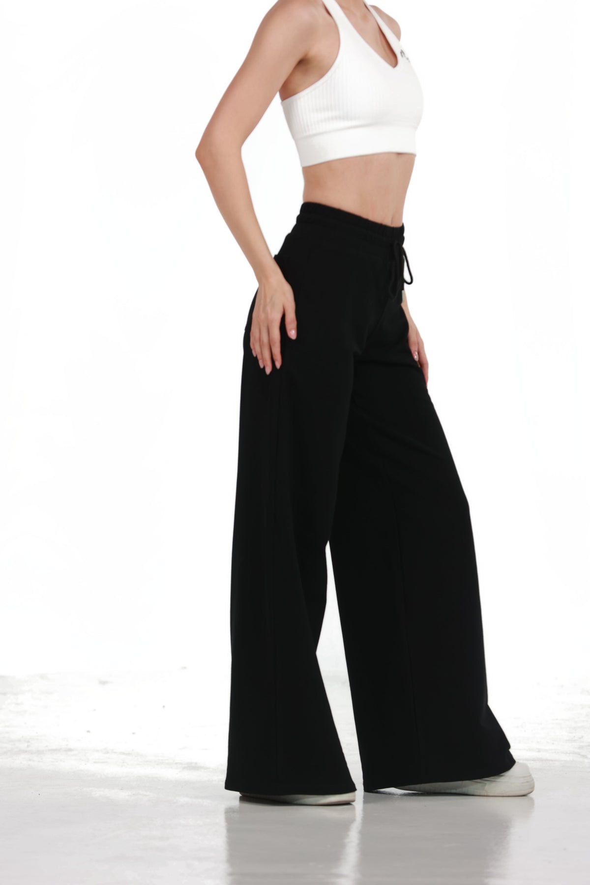 Low Fit Cotton Yoga Pants in Black, side view showing the wide leg drape and side pocket, Ascendia