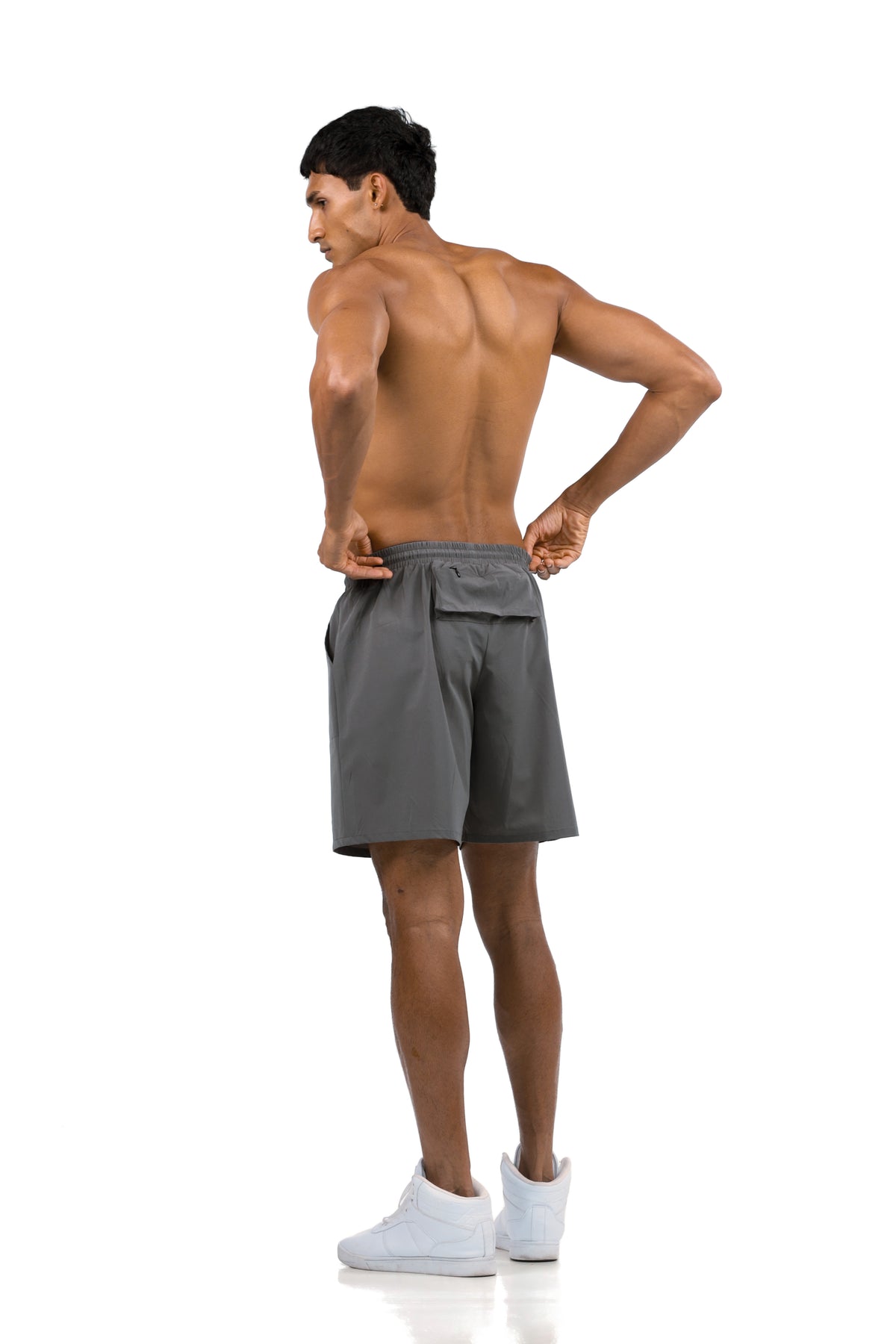 Men's Zip Pocket Running Shorts in Charcoal, three-quarter back view with hands at the waistband on model, Ascendia