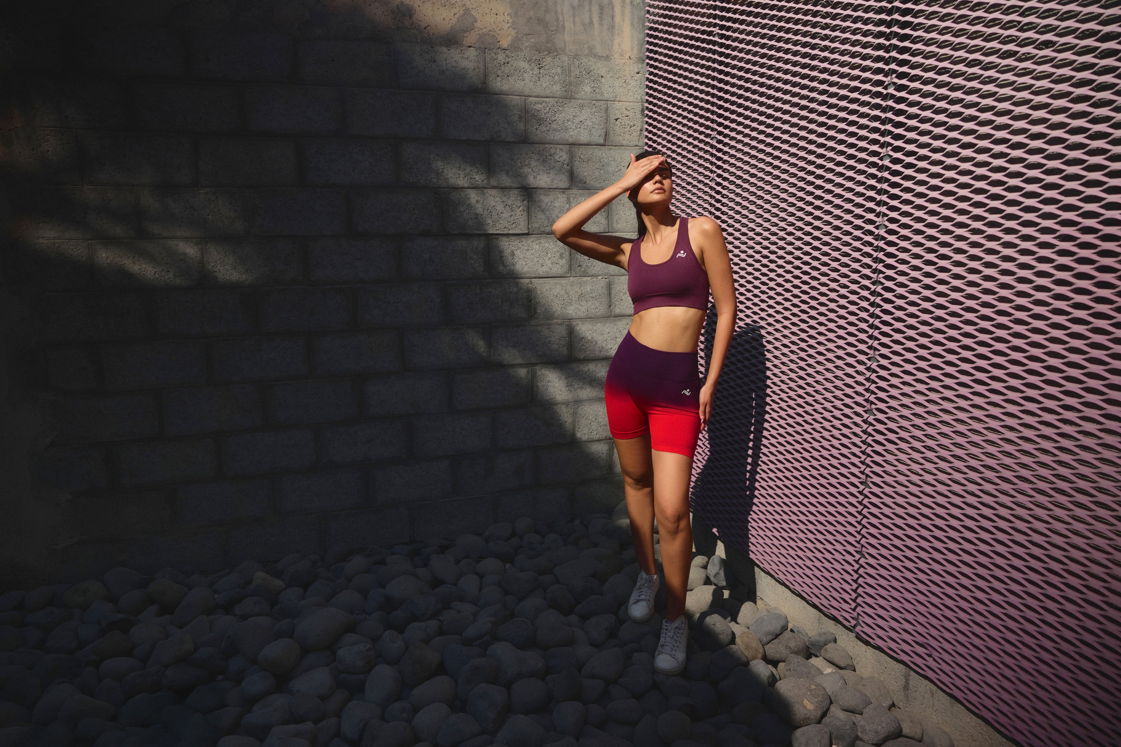 A woman in Ascendia training wear resting against a wall in Dubai