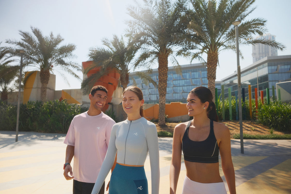 Three people in Ascendia sportswear walking together on a Dubai promenade