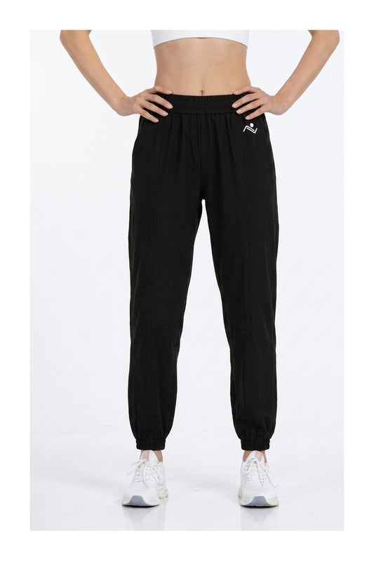 Women's Casual Joggers in Black, front view on model showing the elastic waist and cuffed ankles, Ascendia
